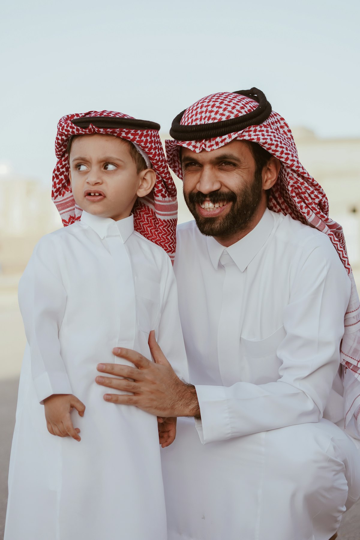 A father and son in traditional Gulf dress